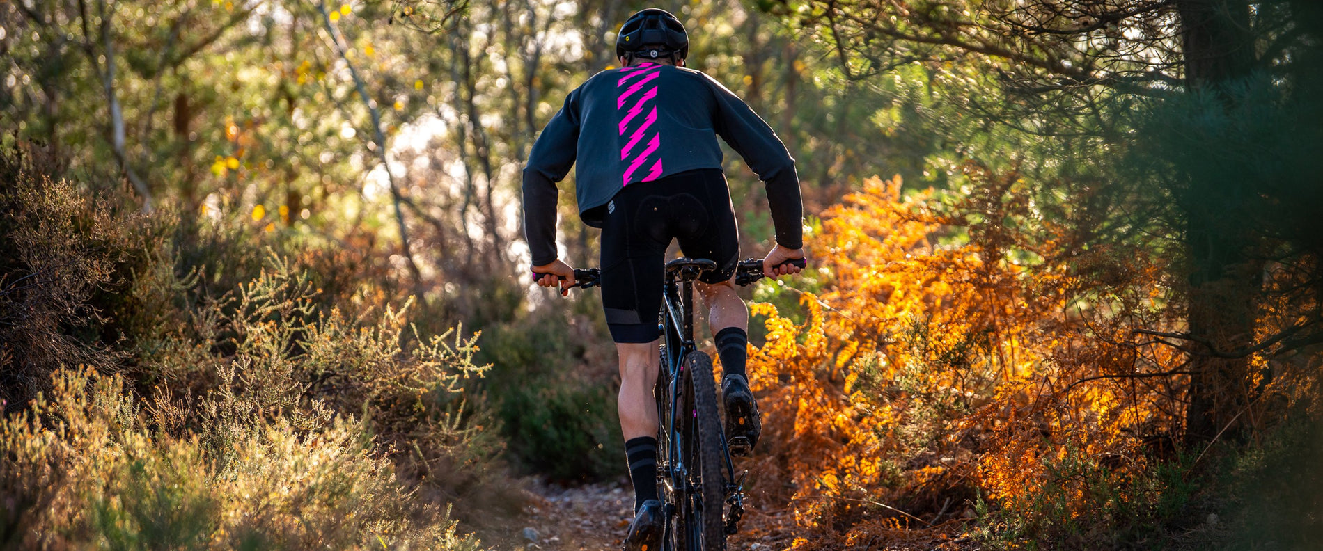 Mountain biker wearing the Muc-Off long sleeve jersey on a forest trail